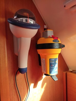 A bathroom with a white and blue showerhead and a yellow and black handheld showerhead.