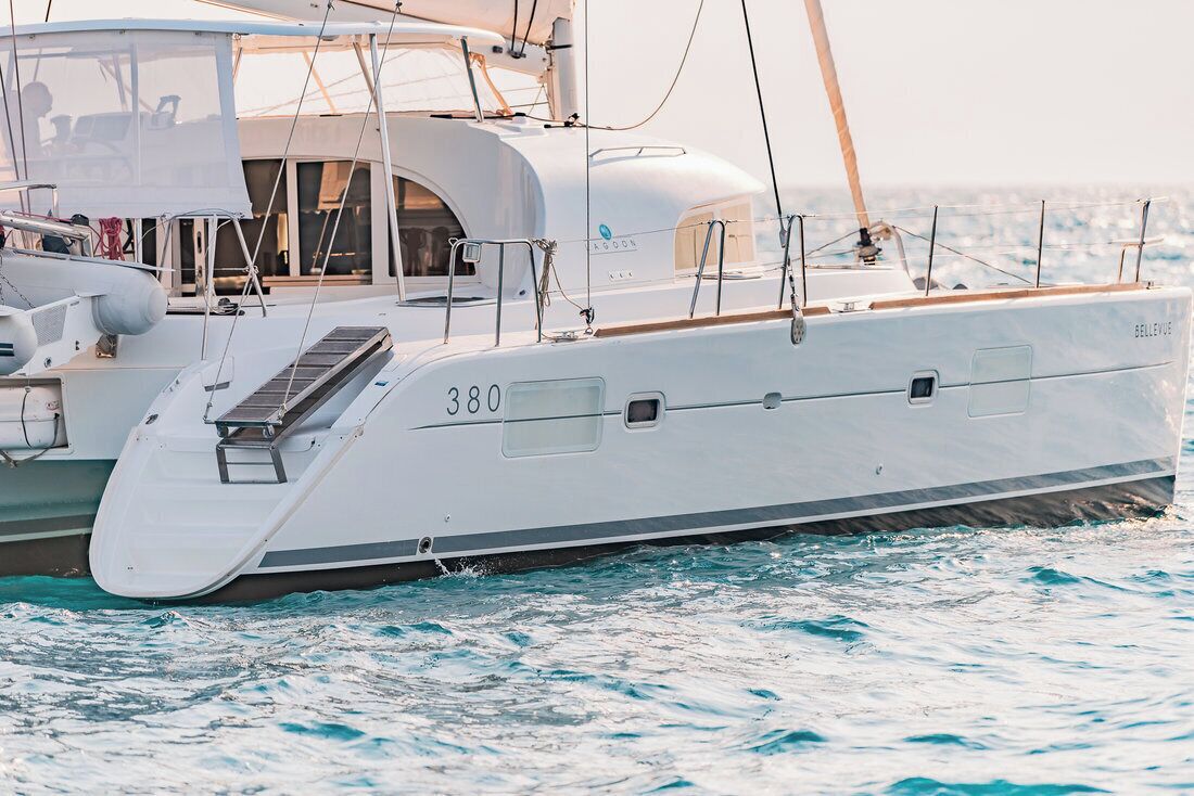 Un yacht blanc portant le numéro 380, doté d’un pont partiellement couvert et d’une structure de cabine.