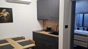 Une cuisine de taille réduite avec une table en bois, des chaises, un évier et des placards.