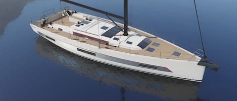 Un yacht blanc doté d’un pont, d’un mât et d’une structure de cabine.