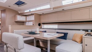 Un intérieur de camping-car compact comprenant un coin repas, un coin cuisine et un petit espace nuit.