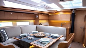Un interior compacto y bien iluminado con comedor, asientos y kitchenette.
