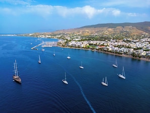 An aerial view of a coastal town with a marina filled with sailboats.