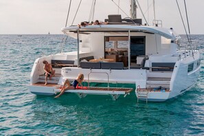 A yacht with a covered deck, seating area, and a small table.