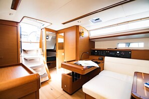 A well-lit, compact interior with a kitchenette, seating area, and storage compartments. - Sun-Kissed Sailing Adventure in the Stunning Islas Cícladas (Paros)