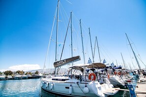 A marina with multiple sailboats docked, clear skies, and calm water. - Sun-Kissed Sailing Adventure in the Stunning Islas Cícladas (Paros)