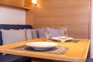 A dining table with two plates, two glasses, and a fork. - Sun-Kissed Sailing Adventure in the Saronic Islands (Laurium)