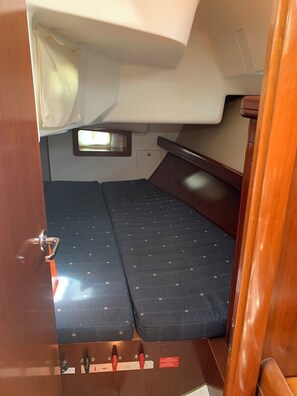 Un intérieur compact comprenant un lit, une petite fenêtre et un panneau de commande.