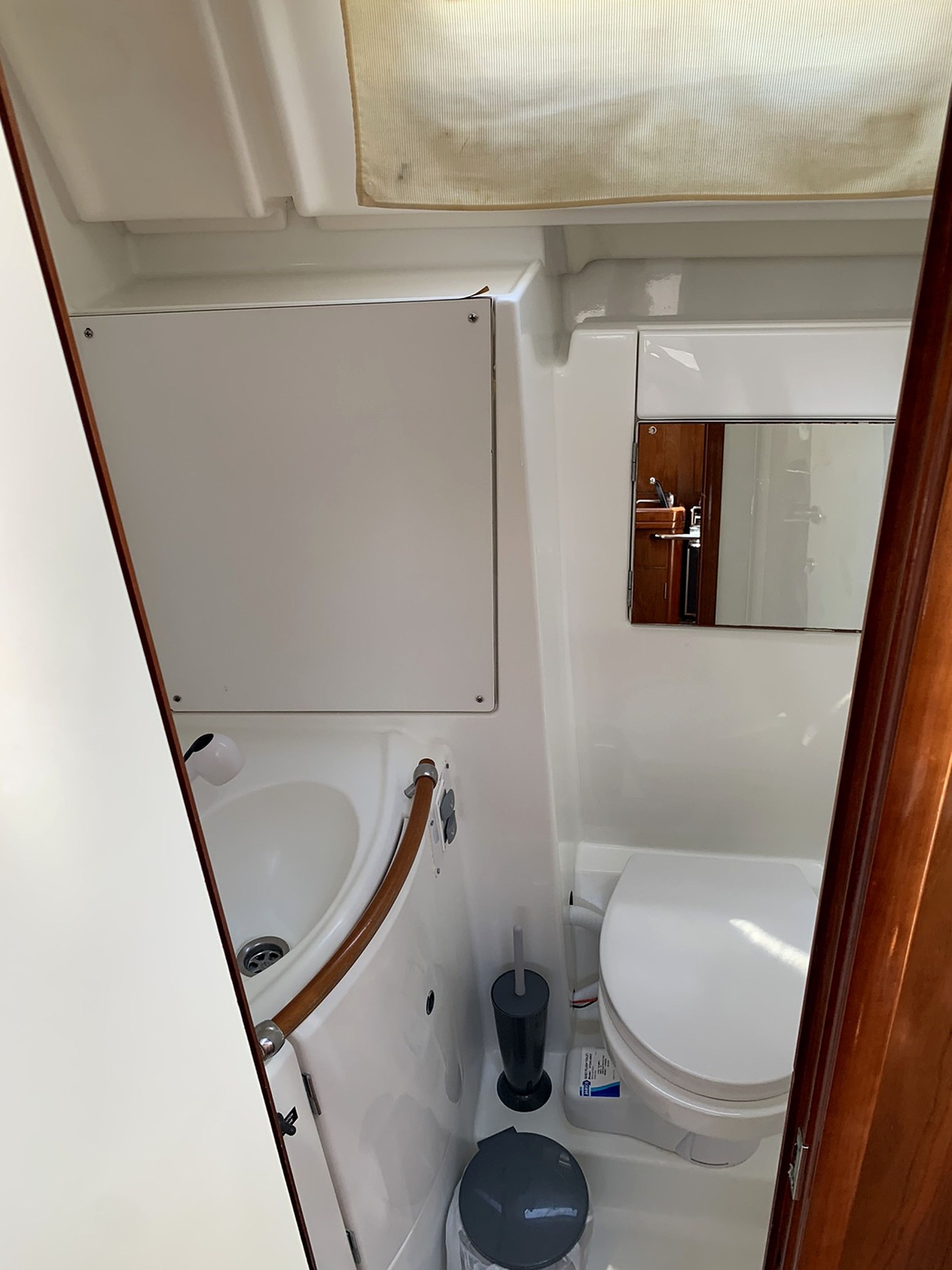 A compact bathroom with a white sink, toilet, and mirror.
