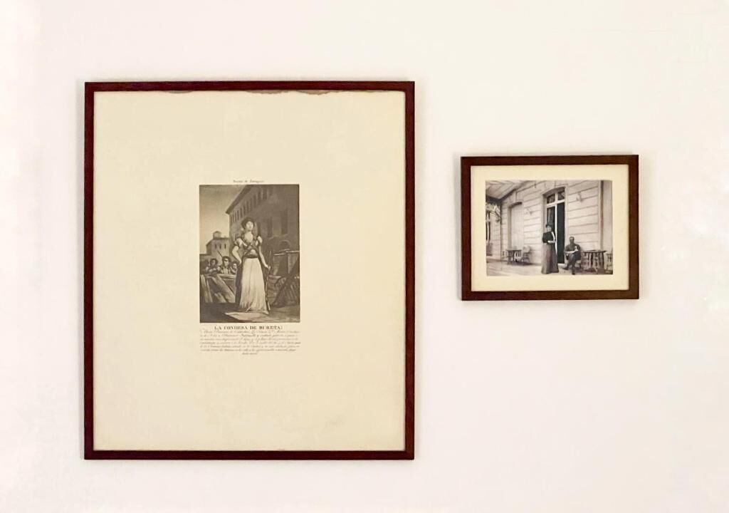 Twee zwart-witfoto's in lijsten aan een muur.