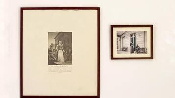 Twee zwart-witfoto's in lijsten aan een muur.