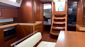 A compact galley with a stove, oven, and wooden cabinets.