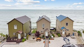 Una proprietà fronte spiaggia con tre case, un patio e vista sull'oceano.
