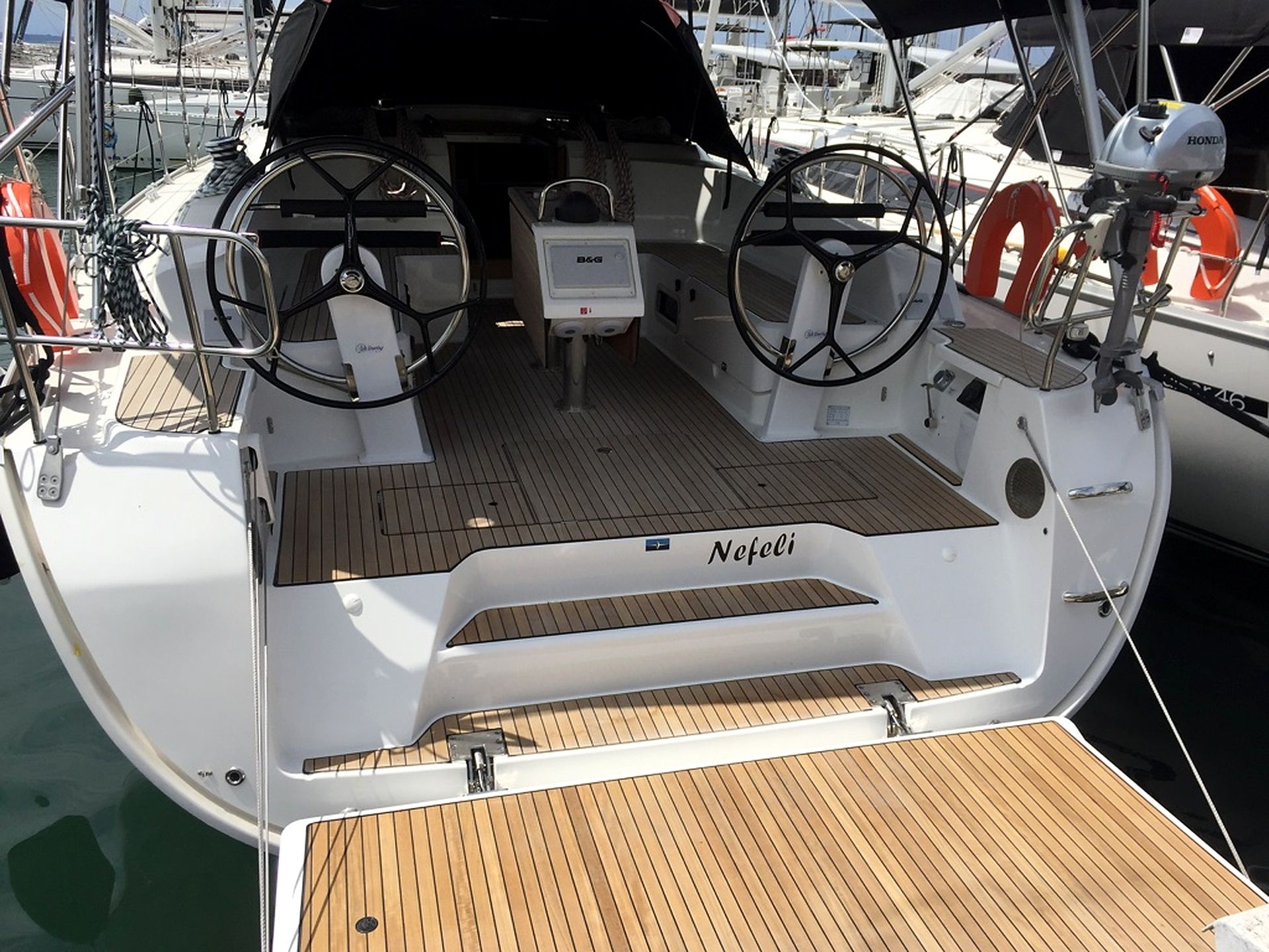 A boat's deck with a steering wheel, a control panel, and a nameplate reading 'Neefeli'.