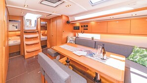 Een compact, goed verlicht interieur met een eethoek, zitplaatsen en een bedieningspaneel.