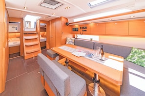 Un intérieur compact et bien éclairé, comprenant un espace repas, des sièges et un panneau de commande.