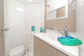 Ein modernes Badezimmer mit Toilette, Waschbecken mit Armatur und einem Spiegel über dem Waschbecken.