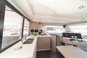 Une cuisine de taille réduite, équipée d’un évier, d’une cuisinière et d’un petit plan de travail.
