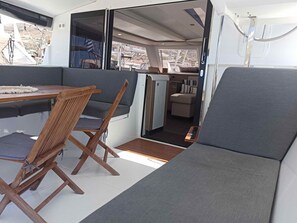 Un intérieur moderne et compact comprenant un coin repas, des sièges et une petite kitchenette.