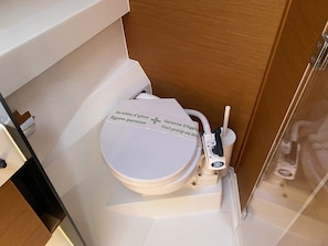 Un baño moderno con inodoro blanco, un bidé y un secamanos.