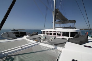 A sailboat deck with seating, a mast, and a view of the sea. - Sun-Kissed Sailing Adventure in Islas Sarónicas (Alimos)