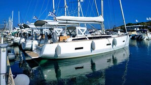 Ein Yachthafen mit mehreren Segelbooten, darunter Masten, Segeln und Flaggen.