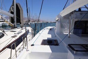 A marina with multiple boats docked, a clear sky, and a calm sea. - Sun-Kissed Sailing Adventure in Islas Sarónicas (Alimos)