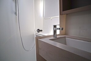 A bathroom with a shower, a sink, and a mirror. - Sun-Kissed Sailing Adventure in Islas Sarónicas (Alimos)