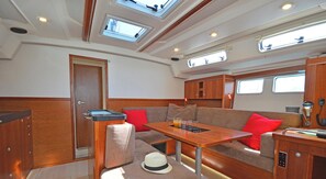 A compact interior with a sofa, table, and a small cabinet. - Sun-Kissed Sailing Adventure in the Dodecanese Islands (Kos)