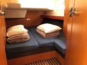 A compact cabin with two beds, each with a pillow and a folded blanket. - Sun-Kissed Sailing Adventure in Islas Sarónicas (Alimos)