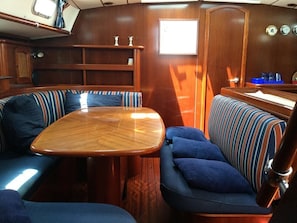 A compact cabin with a wooden table and two upholstered seating areas. - Sun-Kissed Sailing Adventure in the Ionian Islands, Lefkada (Lefkada)
