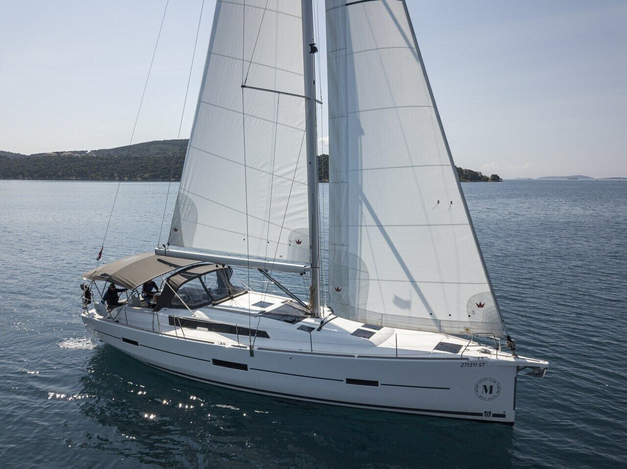A sailboat on calm water with a clear sky.