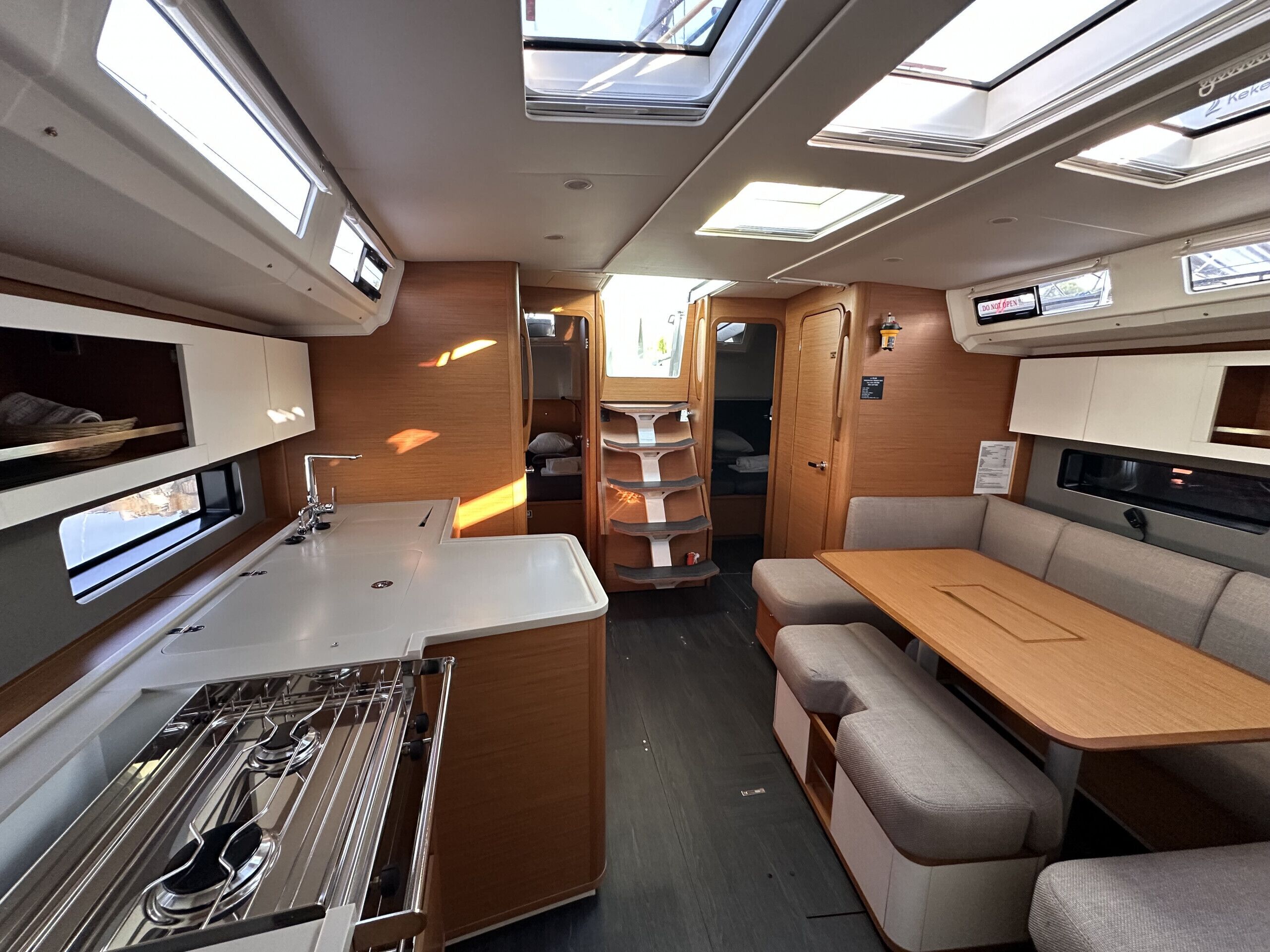 Un intérieur de camping-car compact comprenant un coin cuisine, un espace repas et un coin nuit.