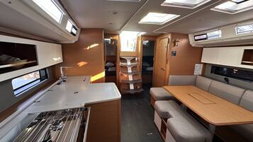 Un intérieur de camping-car compact comprenant un coin cuisine, un espace repas et un coin nuit.
