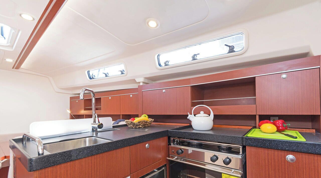 A compact galley with a sink, stove, and cabinets.
