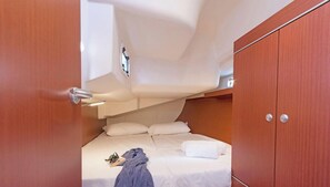 Ein gemütliches Schlafzimmer mit Etagenbett, einem Holzschrank und einem kleinen Fenster.