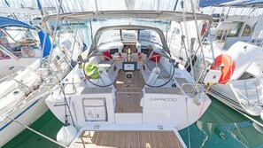 A boat deck with a central seating area, a steering wheel, and a life buoy.
