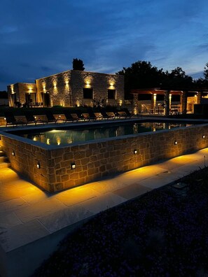 A stone pool with lounge chairs and a stone building with lights. - Maison Lagerstroemie -Exclusive Villa with Private Pool in Le Marche, Filottrano (Filottrano)