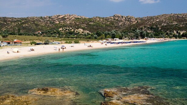 A beach with clear turquoise water, rocky shorelines, and a hilly backdrop. - Sun-Kissed Sailing: A Luxurious Beach Experience in Nikiti, Macedonia (Nikiti)
