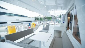 A yacht interior with a dining area, seating, and a view of the marina. - Sun-Kissed Sailing: A Luxurious Beach Experience in Nikiti, Macedonia (Nikiti)