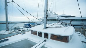 A sailboat docked at a marina with multiple masts and sails, a covered area with seating, and a view of the water. - Sun-Kissed Sailing: A Luxurious Beach Experience in Nikiti, Macedonia (Nikiti)