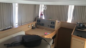 A compact room with a bed, a small kitchenette, a control panel, and a window with curtains. - Sun-Kissed Sailing Adventure in the Ionian Islands, Lefkada (Lefkada)