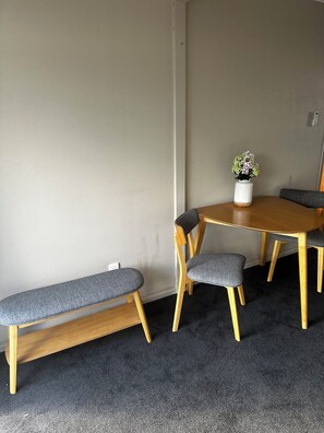 A room with a round wooden table, two grey upholstered chairs, a bench, and a potted plant on the table. - GREY STREET HAVEN!
Relax and unwind in this peaceful home, (Rotorua)
