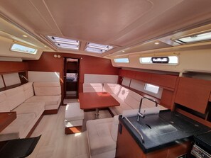 A compact interior with a kitchenette, seating area, and a small table. - Sun-Kissed Sailing Adventure in the Saronic Islands (Laurium)