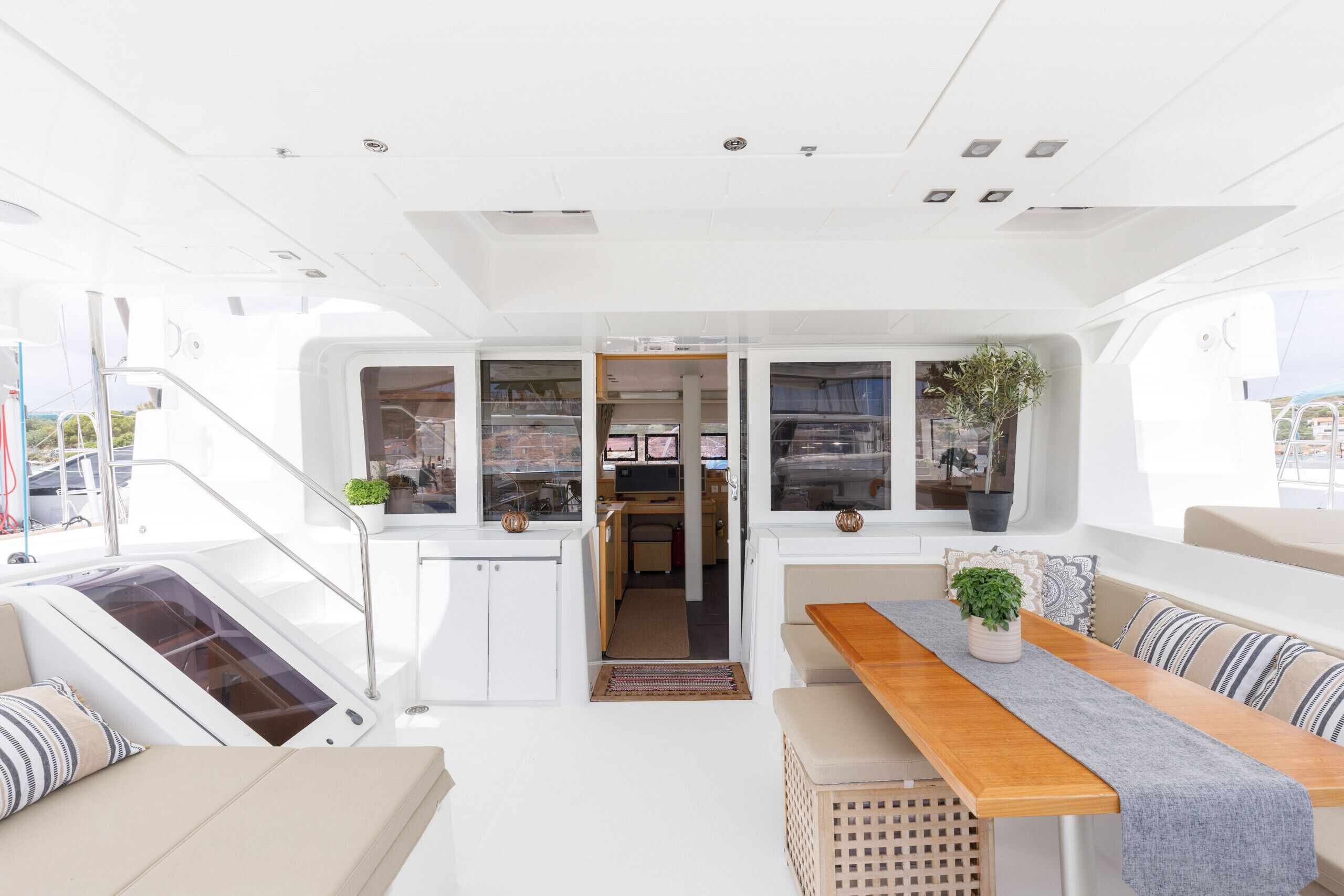 A boat interior with a dining area, kitchen, and seating.