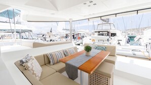 Jachteninnenausstattung mit einer Sitzecke, einem Tisch und Blick auf andere Yachten.