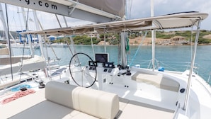 Ein Bootsdeck mit Steuer, Bedienfeld und Sitzgelegenheiten.