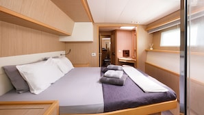 Ein modernes Interieur mit einem Bett, einem kleinen Badezimmer und einem Fenster.