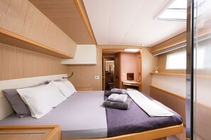 A modern interior with a bed, a small bathroom, and a window. - Sun-Kissed Sailing Adventure in the Saronic Islands (Laurium)