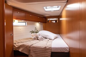 A compact bedroom with a bed, a window, and a small cabinet.